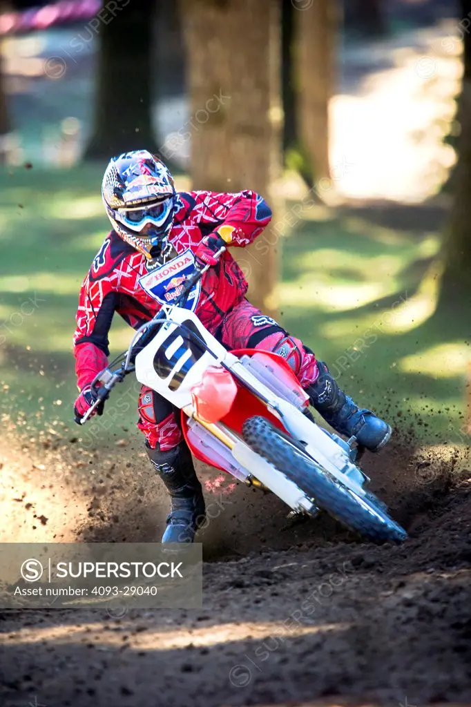 2008 Honda CRF 450R with rider Ivan Tedesco on dirt track course in forest, front view