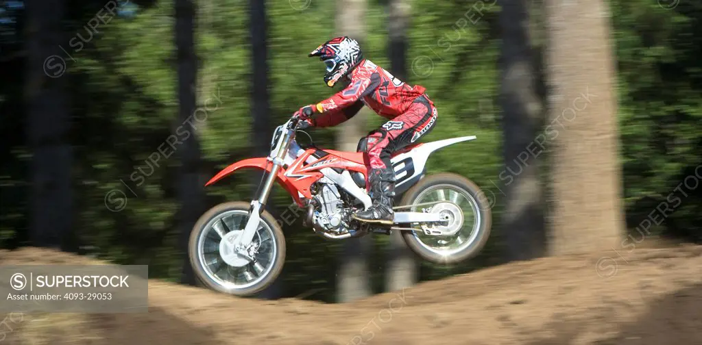 2008 Honda CRF 450R with rider Ivan Tedesco on dirt track course in forest in action, side view