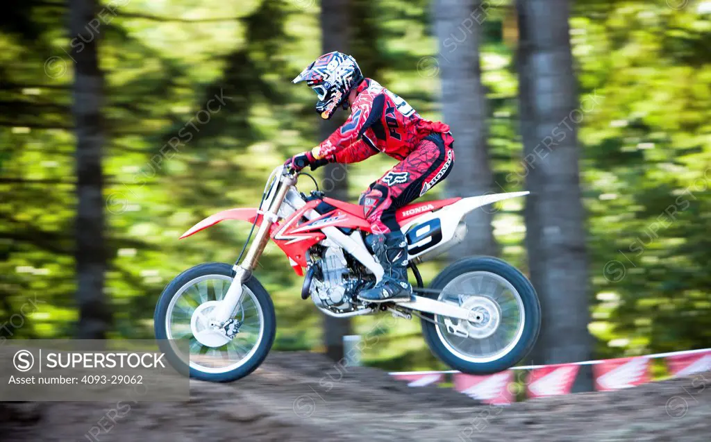 2008 Honda CRF 450R with rider Ivan Tedesco on dirt track course in forest, side view