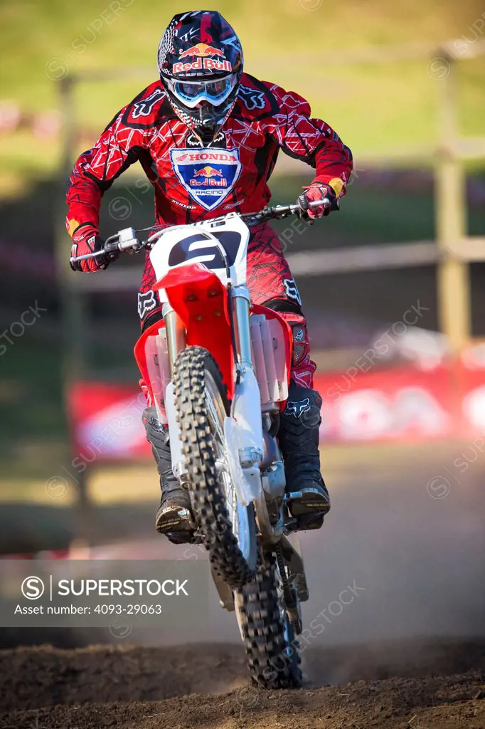 2008 Honda CRF 450R with rider Ivan Tedesco on dirt track course in forest, action, front view