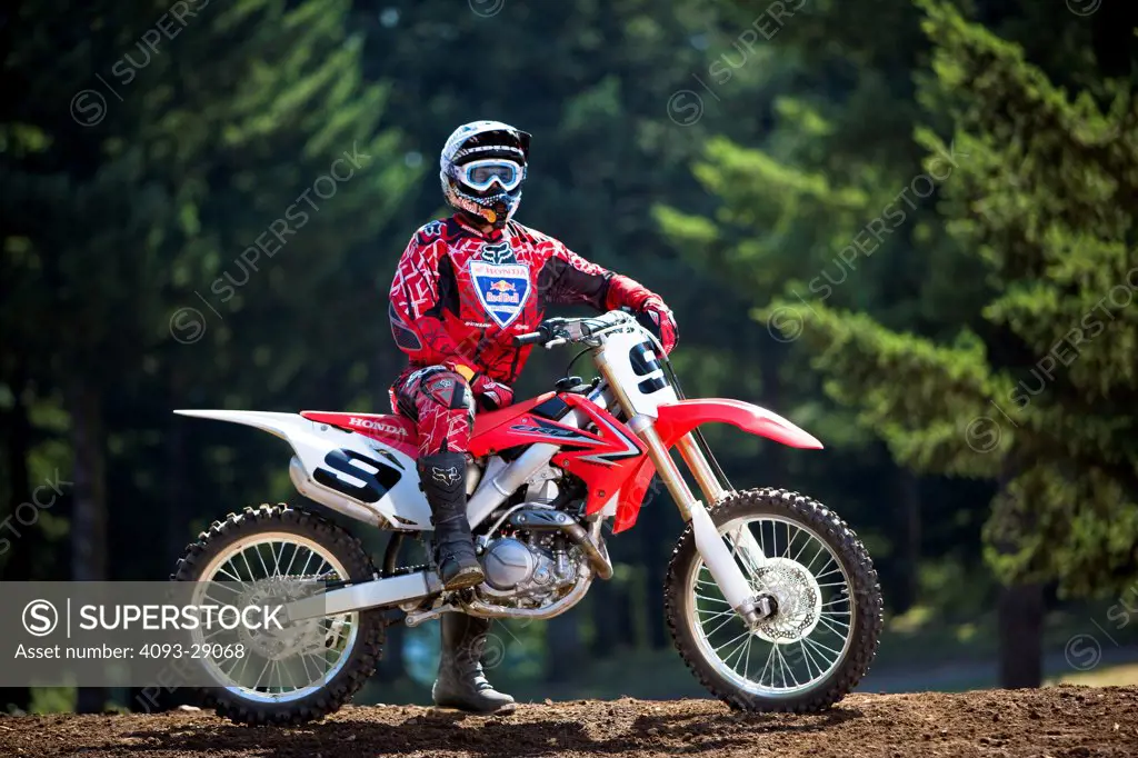 2008 Honda CRF 450R with rider Ivan Tedesco on dirt track course in forest, parked, side view