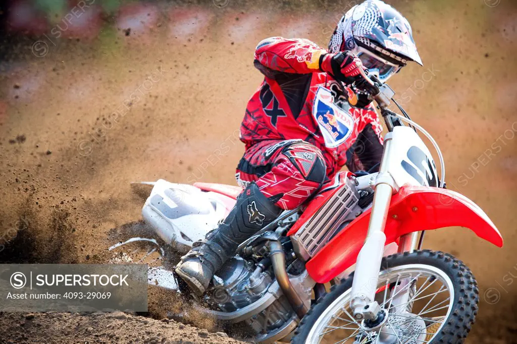 2008 Honda CRF 450R with rider Ivan Tedesco on dirt track course in forest, front 3/4