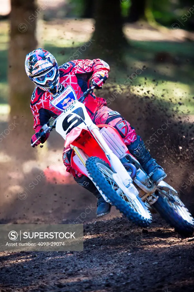 2008 Honda CRF 450R with rider Ivan Tedesco on dirt track course in forest, front 3/4