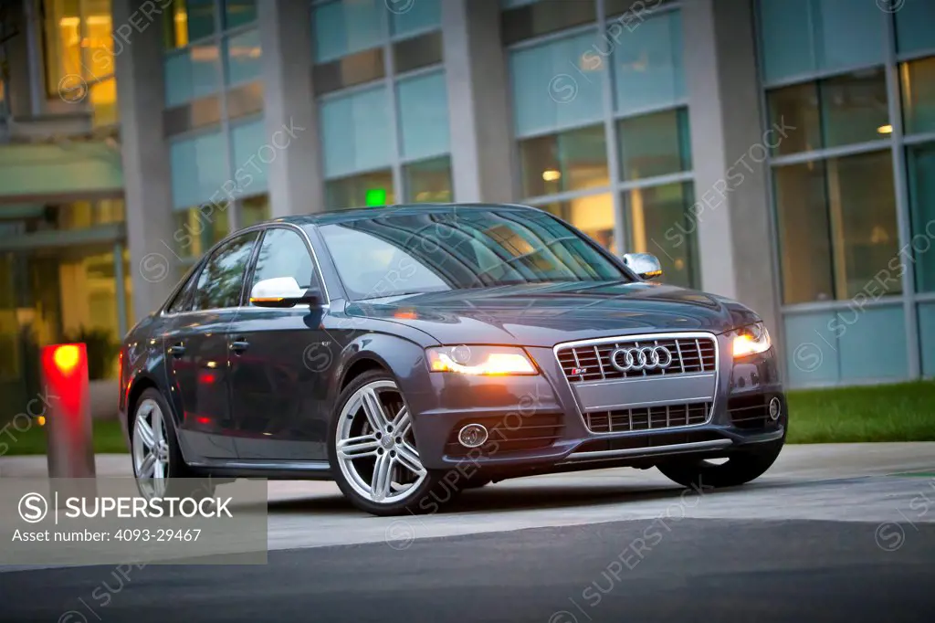 Front 3/4 static view of a gray 2012 Audi S4 parked in front of a commercial office building.