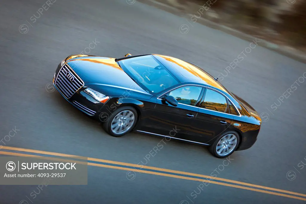 Overhead front 3/4 view of a black 2012 Audi A8 on a rural mountain asphalt road.