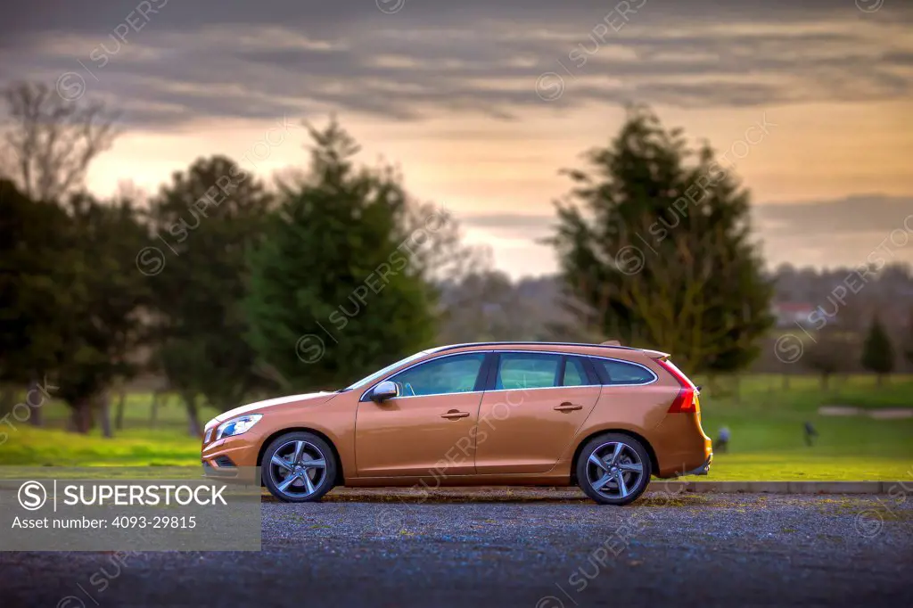 Static profile of an orange 2013 Volvo V60 wagon with DRIVe diesel engine