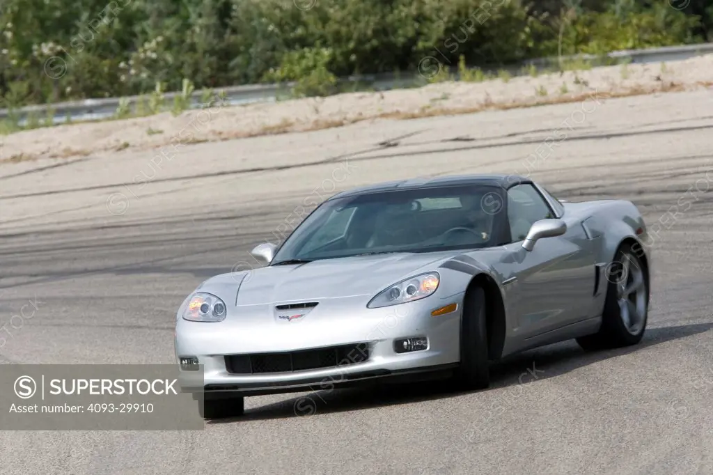 2010 Chevrolet Corvette Grand Sport driving on a race track, front 3/4 action view