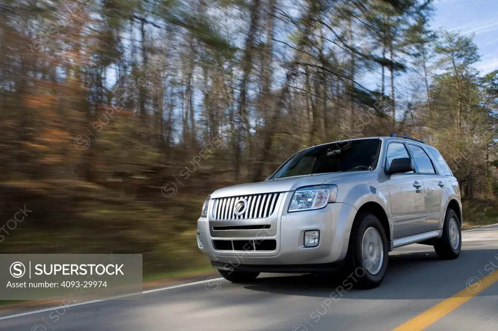 2010 Mercury Mariner V-6 AWD on a rural road, front 3/4 action view