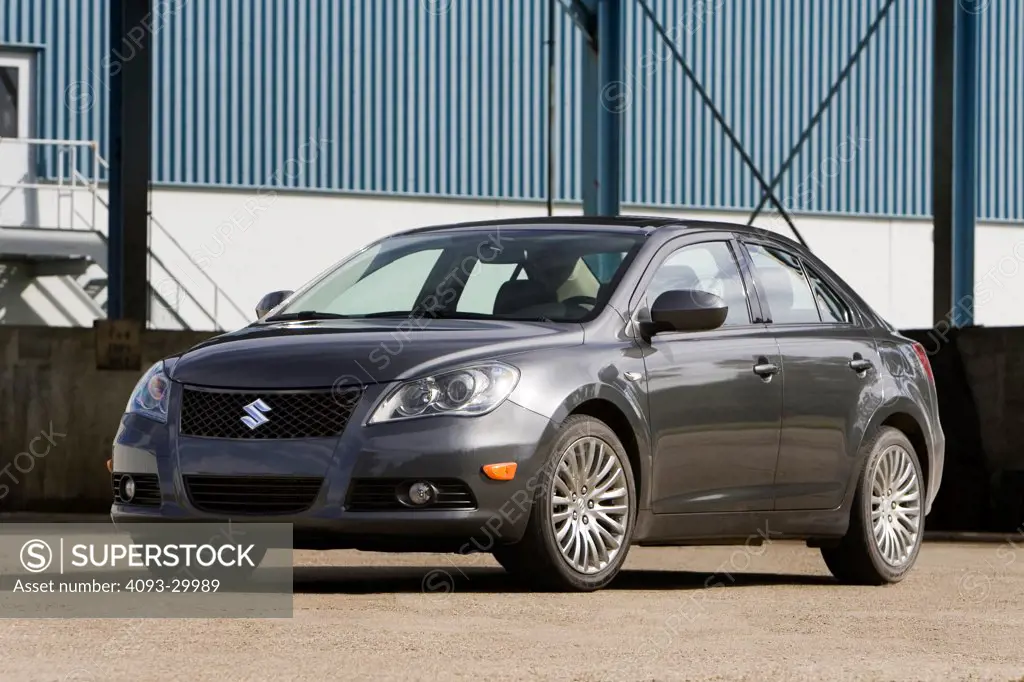 2010 Suzuki Kizashi parked in front of an industrial location, front 3/4 static view