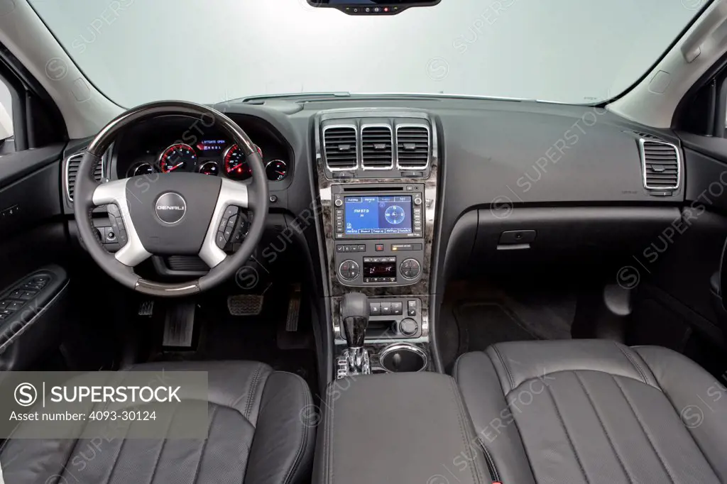 2011 GMC Acadia Denali showing the steering wheel, instrument panel, dashboard, center console, gear shift lever and GPS navigation system