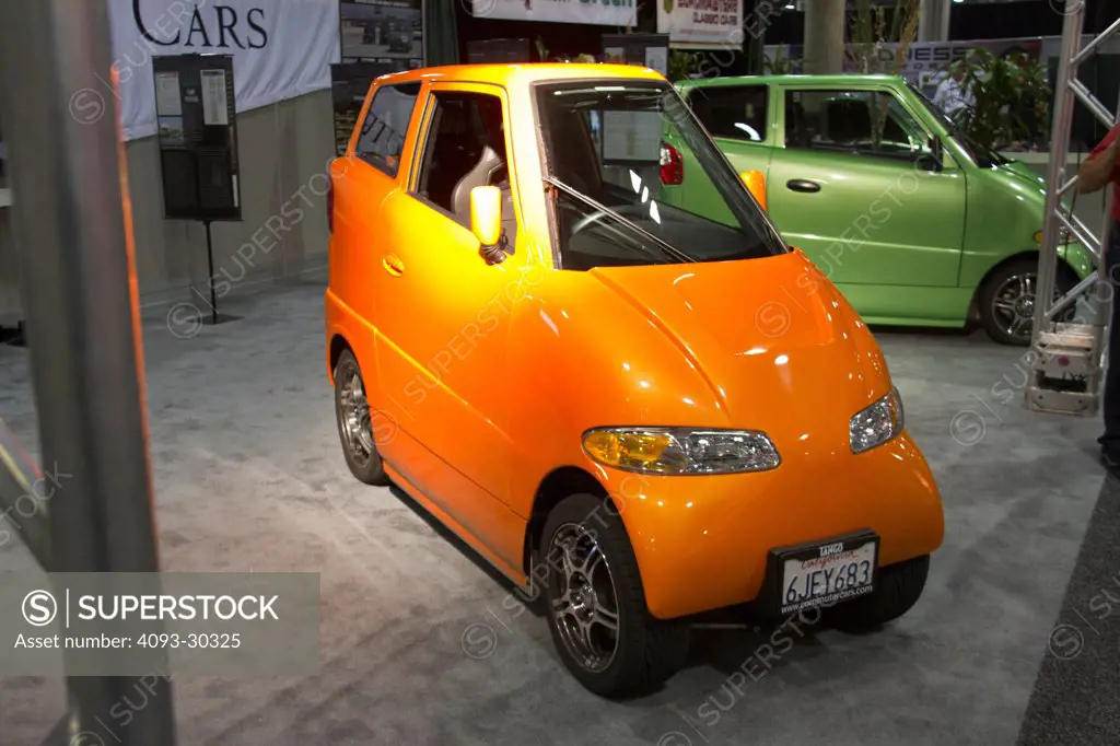 Front 3/4 static view of an orange Tango electric car at the 2010 Los Angeles Auto Show