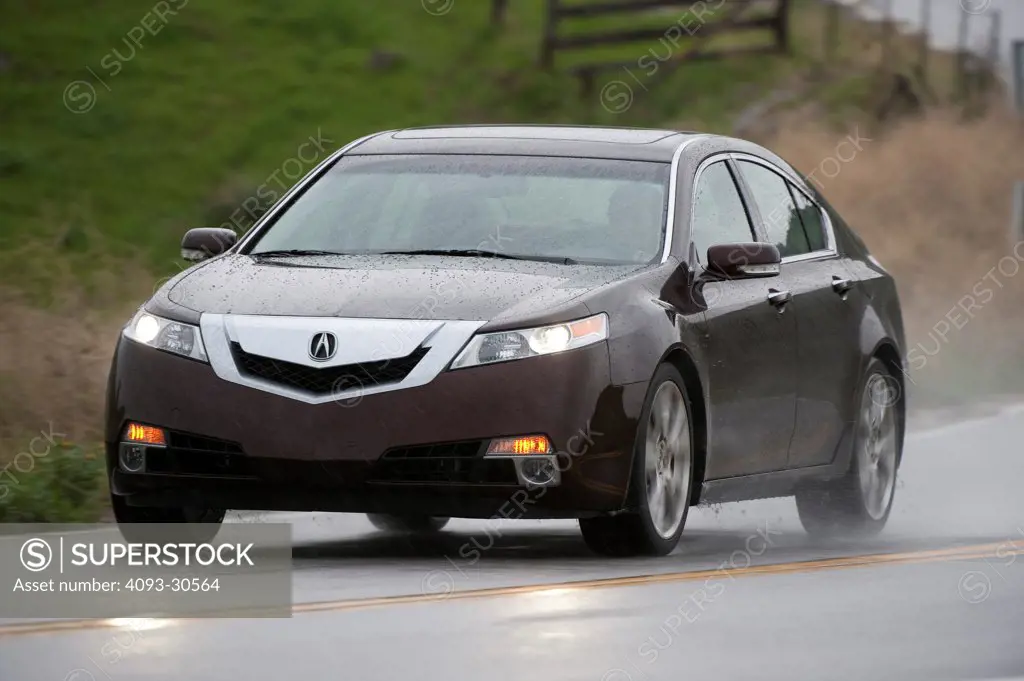 2011 Red Acura TL SH-AWD driving on a rural mountain road in the rain, front 3/4 action view