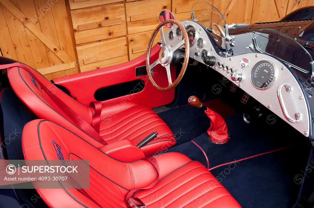 2011 Allard J2x MkII Commemorative Edition interior showing the wood steering wheel, dashboard, instrument panel, gear shift lever and red leather seats