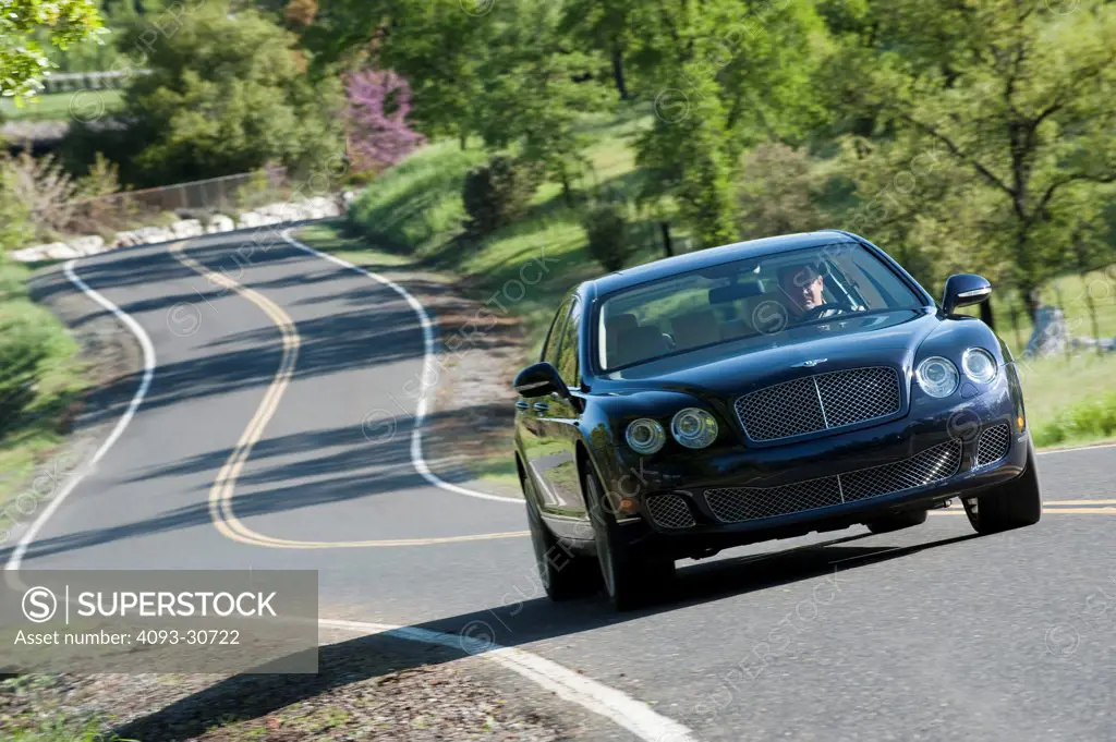 2011 Black,bentley Continental Flying Spur Speed driving on a winding rural road, front 3/4 action view