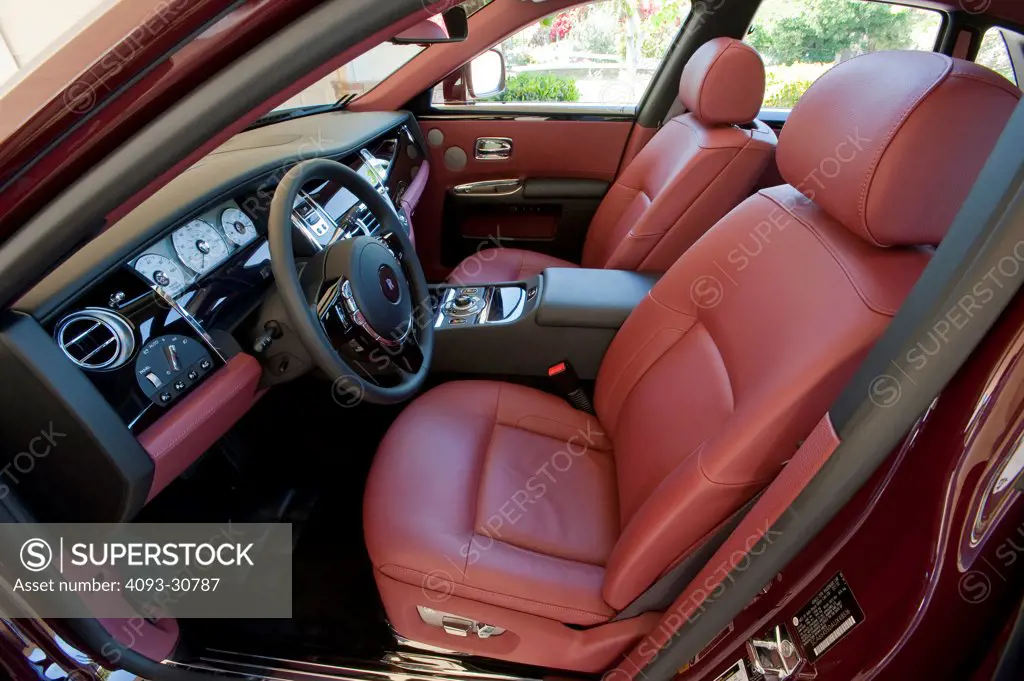 2011 Rolls Royce Ghost interior showing the steering wheel, dashboard and red leather front seats