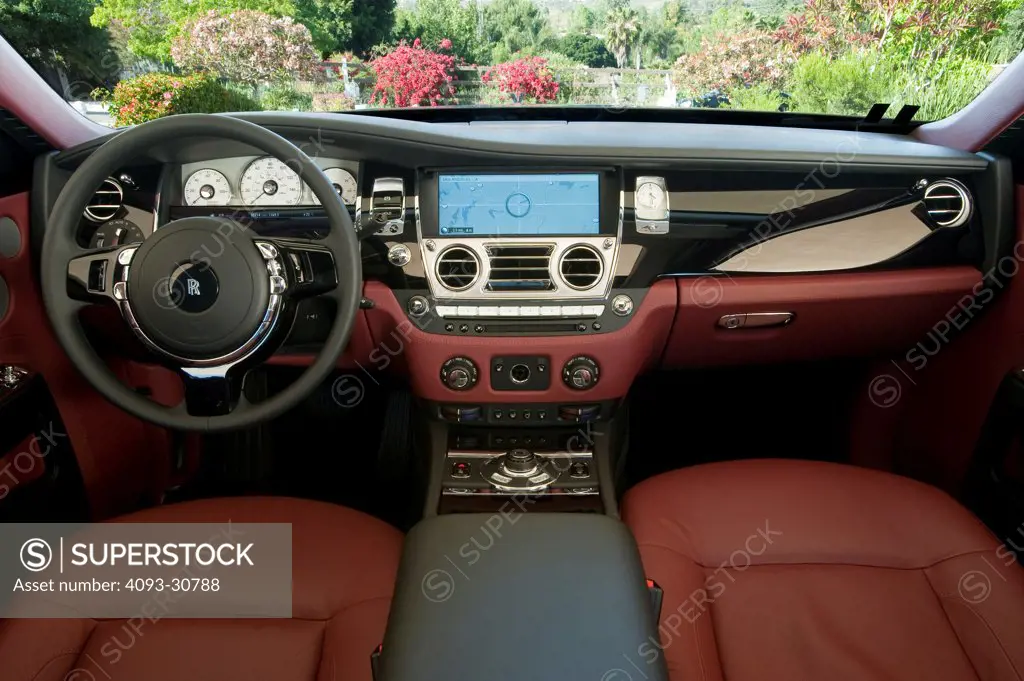 2011 Rolls Royce Ghost interior showing the steering wheel, instrument panel, dashboard, center console, GPS navigation system and red leather seats