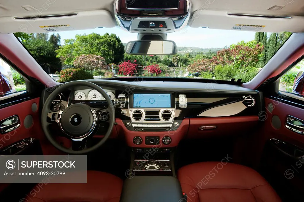 2011 Rolls Royce Ghost interior showing the steering wheel, instrument panel, dashboard, center console, GPS navigation system and red leather seats