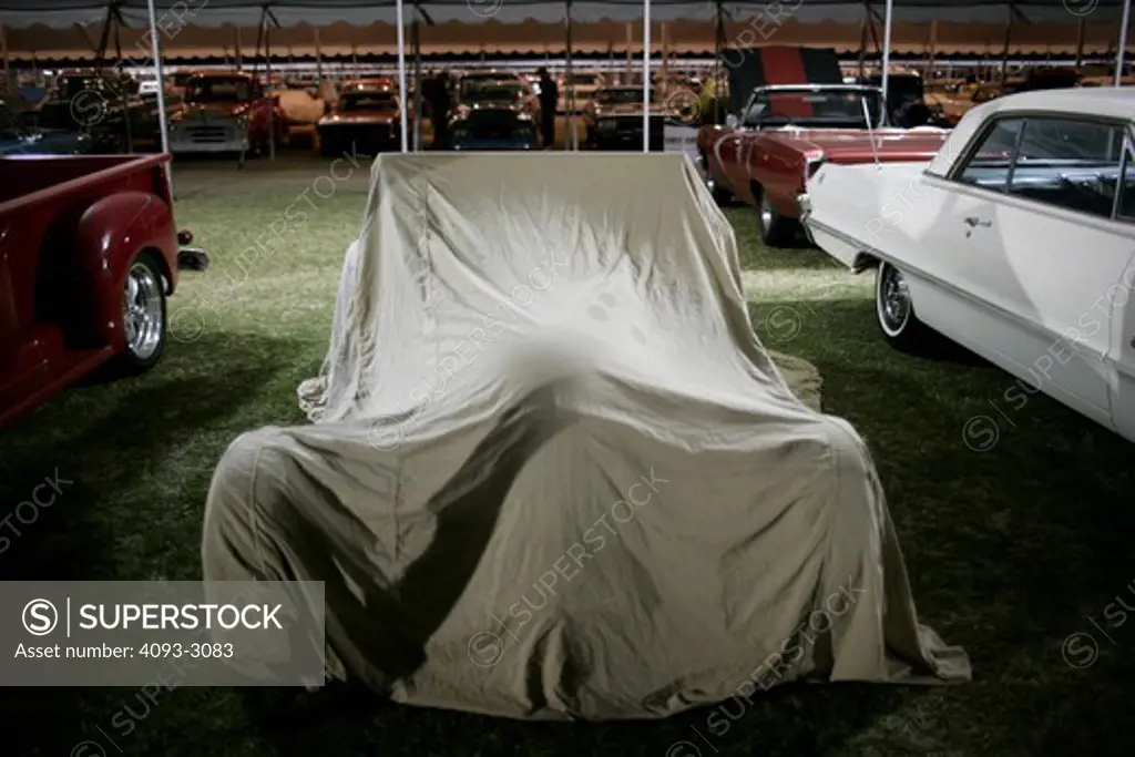 Hot Rod under a cover at the Barrett Jackson auction