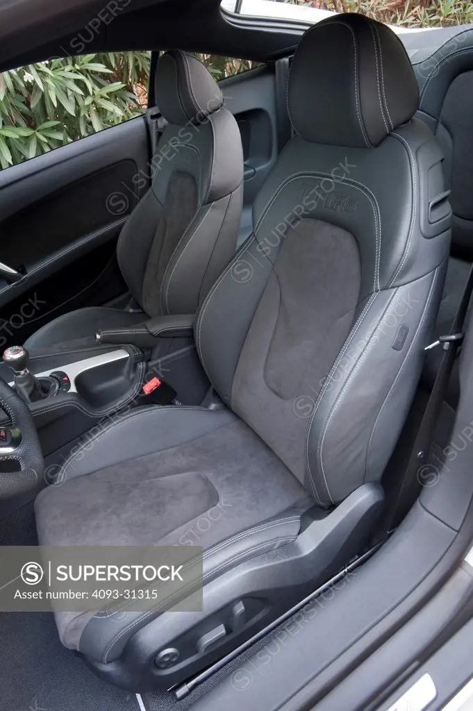 Driver's side view of the interior of a 2012 Audi TT RS showing the driver's seat with the door open.