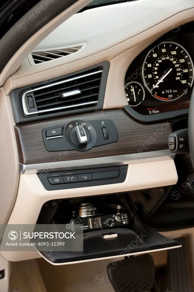 Detail view of a dash pocket, controls and tachometer of a 2012 BMW 750Li