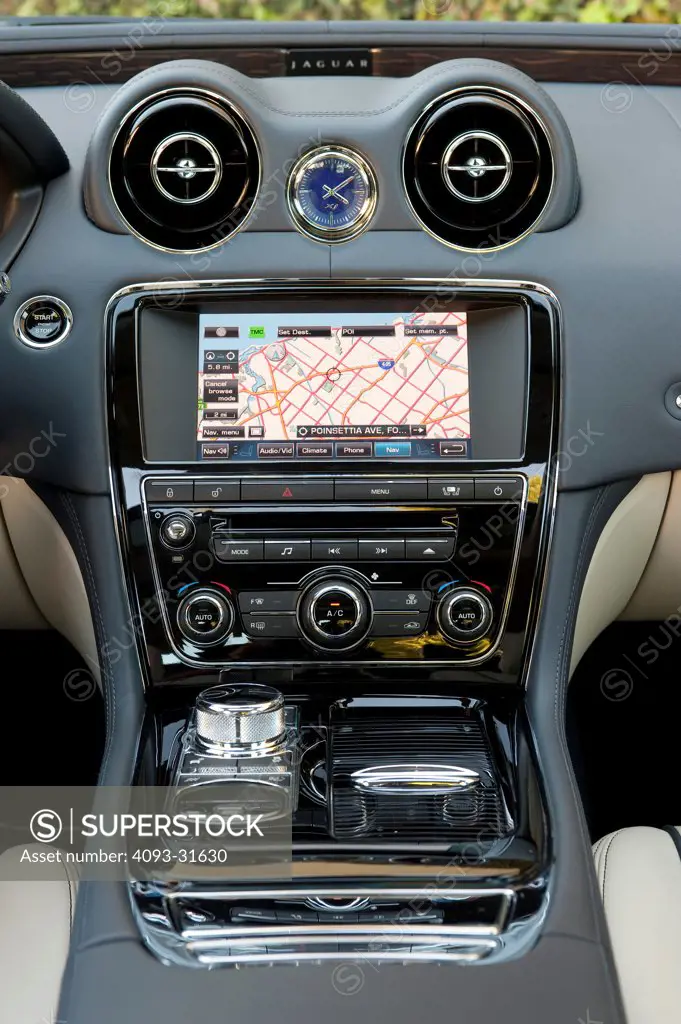 Detail of the center console of a 2012 Jaguar XJL showing the Nav screen, stereo, air vents and shifter.