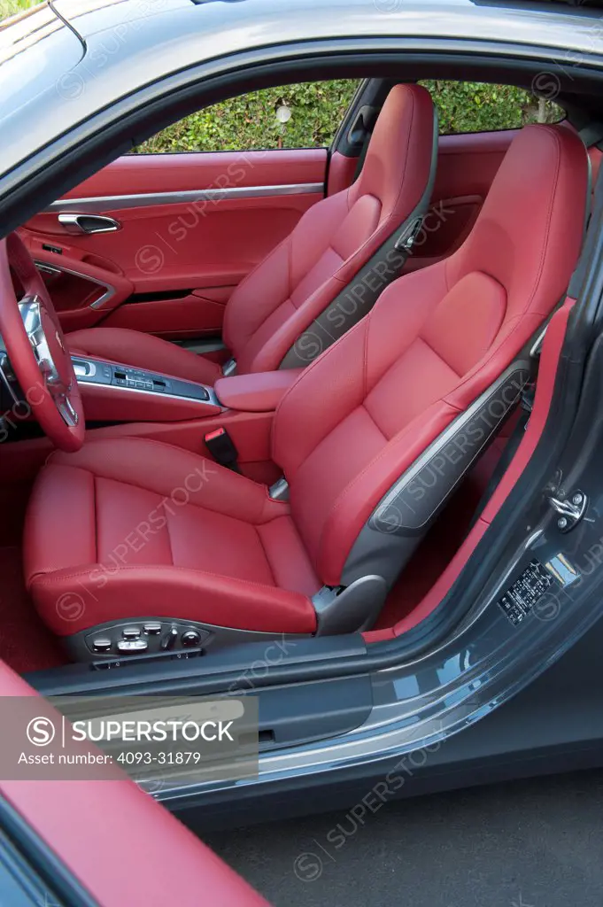 View of the red leather interior from the driver's side of a 2012 Porsche 911 Carrera S. Porsche platform number 991 showing the steering wheel and seats.