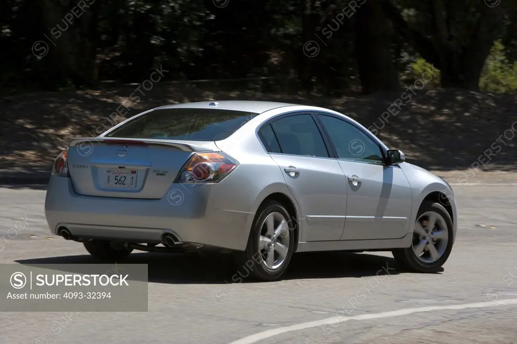 2007 Nissan Altima Hybrid Sedan rear 3/4 action view on suburban road