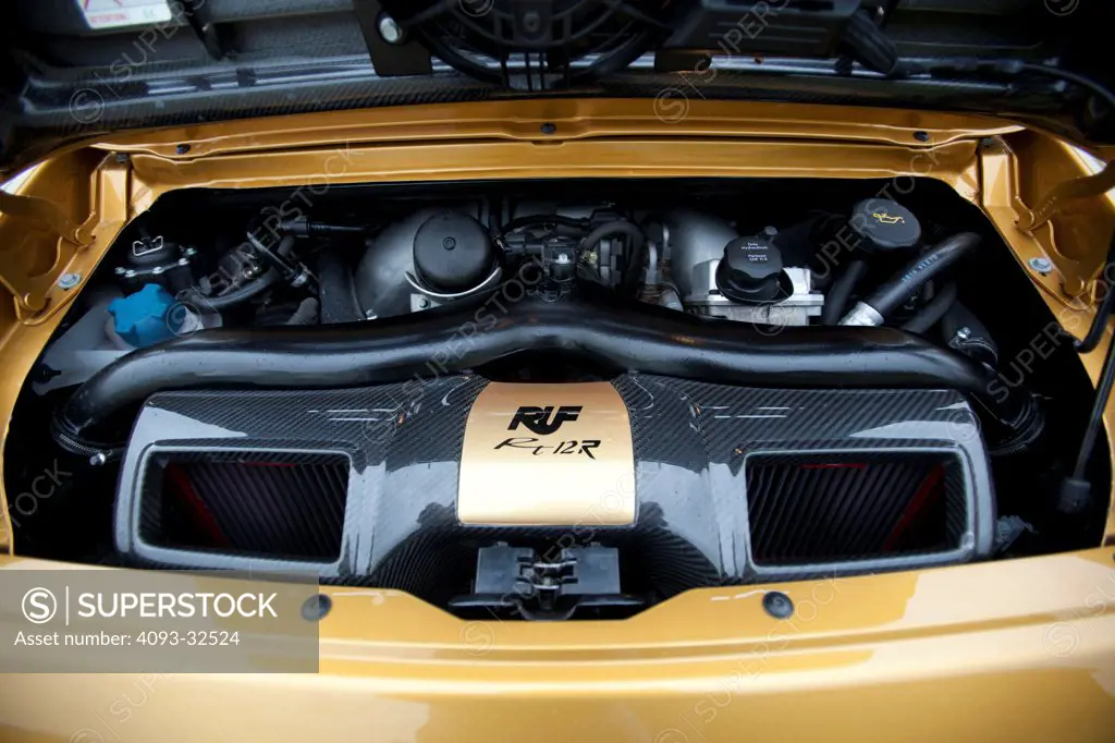 Engine view of a gold 2012 RUF RT12R showing the 3.8 liter twin-turbo flat-six motor. Based on a Porsche 911