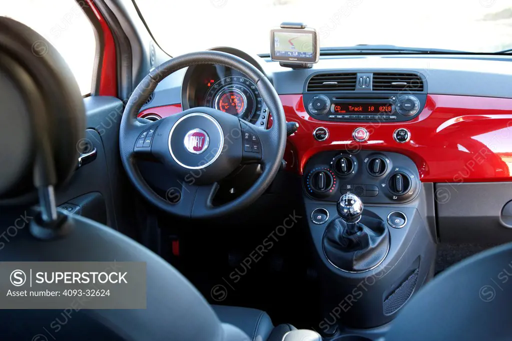 Interior view of a red 2012 Fiat 500 showing the instrument panel, steering wheel, dashboard, center console, multi function display, climate controls, gear shift lever, parking brake and black leather seats.