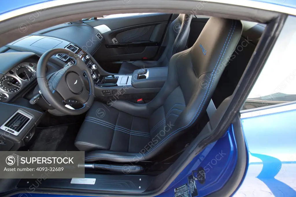 Interior view of a 2012 Aston Martin Vantage S showing the leather seats, steering wheel and dashboard.