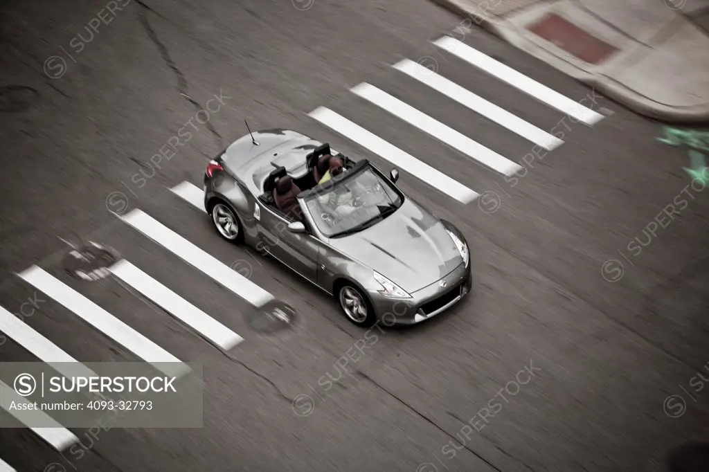 2010 Nissan 370Z Roadster driving through city streets, high angle view