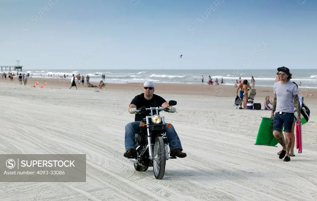 Biker riding on beach, front 3/4
