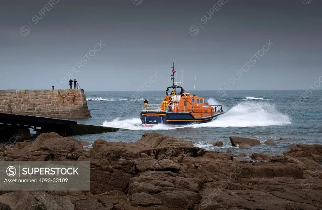 2010 Tamar class lifeboat launch over rocky beach into sea, rear 3/4
