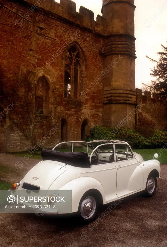 1963 Morris Minor Convertible parked next to an abandoned castle, rear 3/4