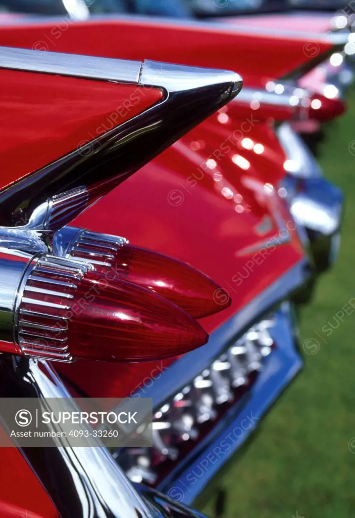 Exterior detail view of a red 1959 Cadillac Eldorado convertible showing the large rear tailfin and tail lights.