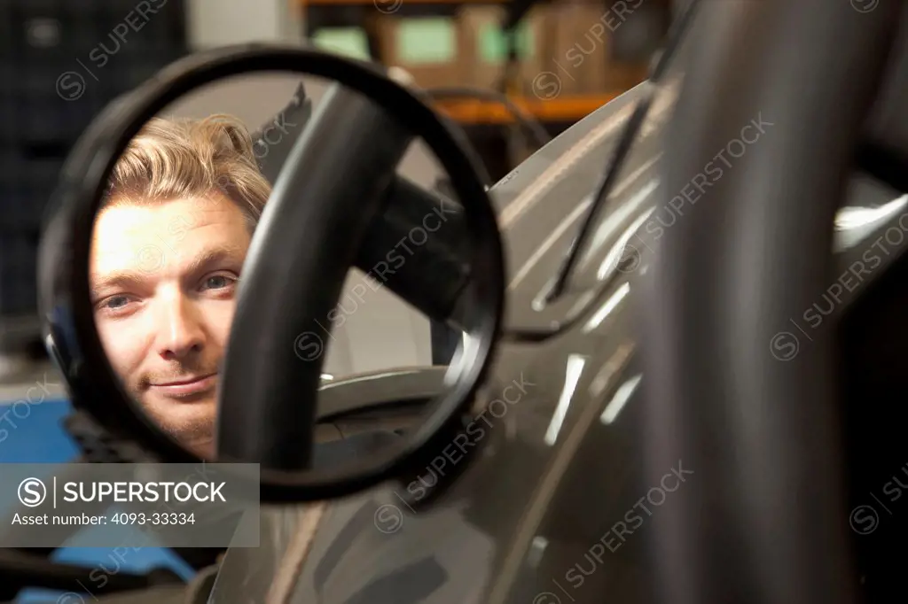 Matthew Humphries Chief designer at Morgan Motor cars looks through a rear view mirror of 2011 Morgan Three wheeler