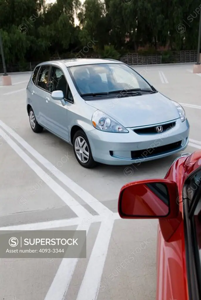 Honda Fit; Nissan Versa aside each other in a parking lot