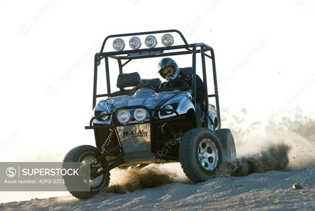 a custom vehicle not unlike a golf cart golfcart that has been modified for off road use.  Action shots showing off road activities.