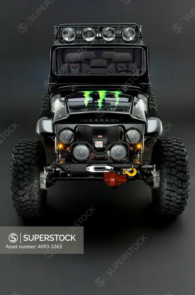 Jeep Wrangler with a Monster energy drink sticker on the hood.  shot in the studio with lighting.