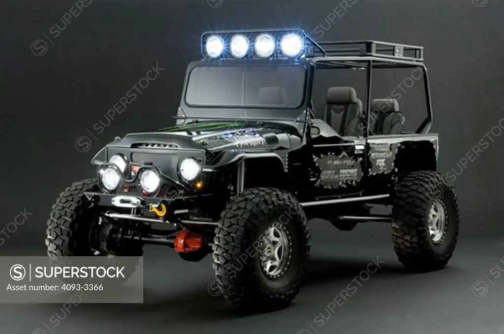Jeep Wrangler with a Monster energy drink sticker on the hood.  shot in the studio with lighting.