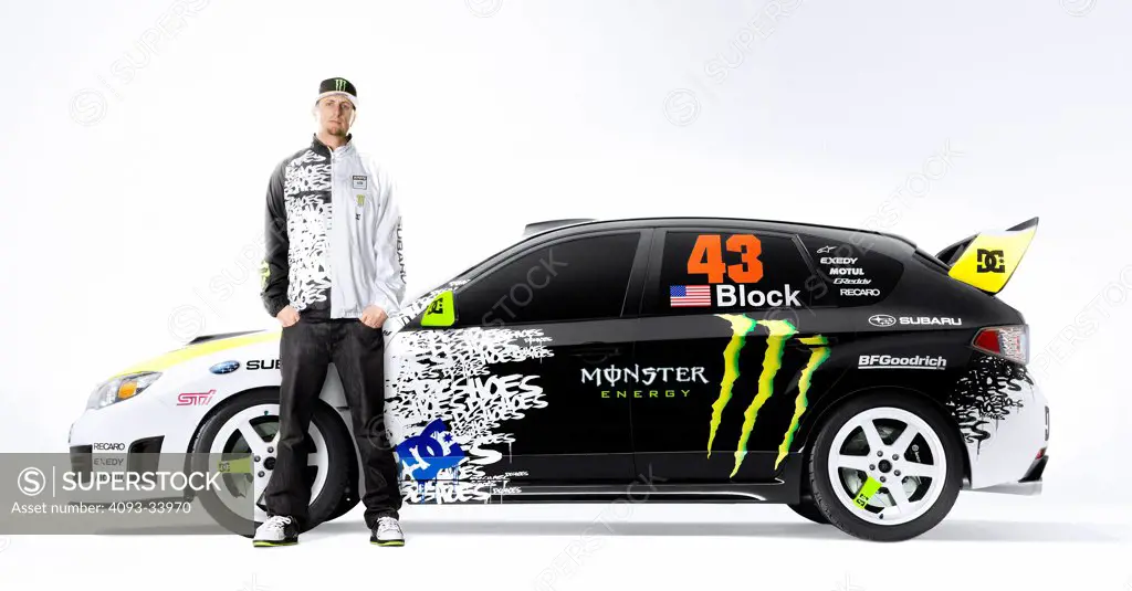 Profile static view of Ken Block and his 2009 Subaru WRX STi in the studio with white background.