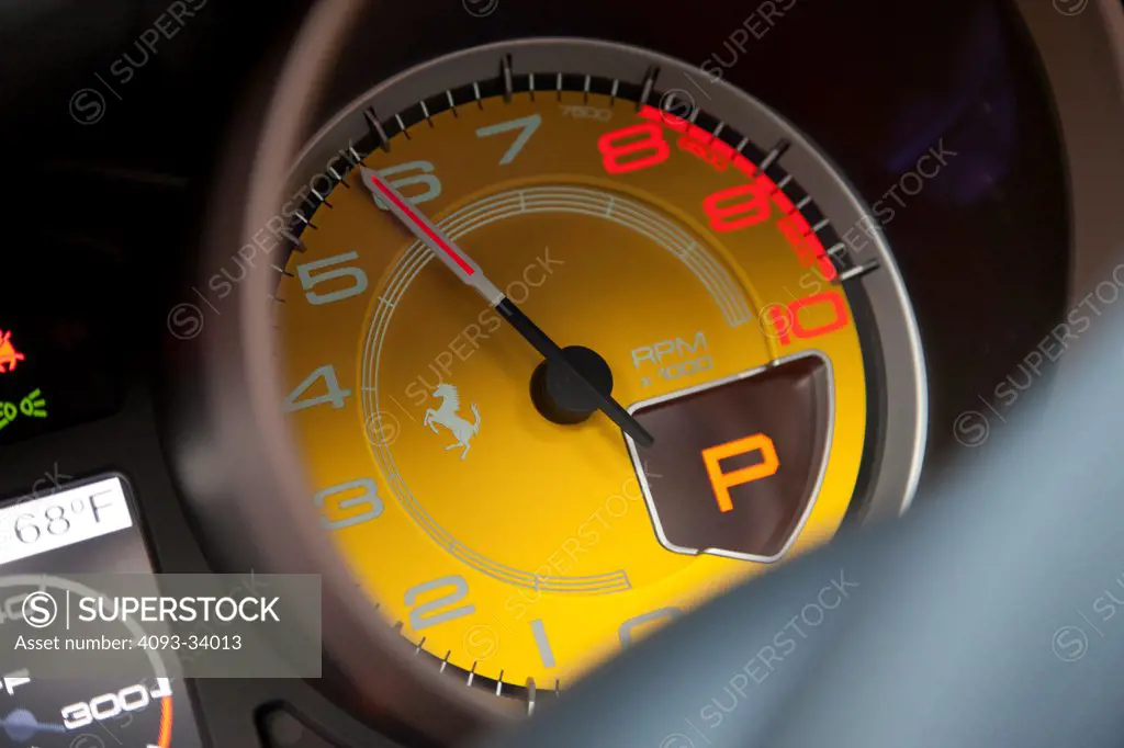 Interior detail view of a 2011 Ferrari California showing the tachometer needle at almost 6000 rpm.