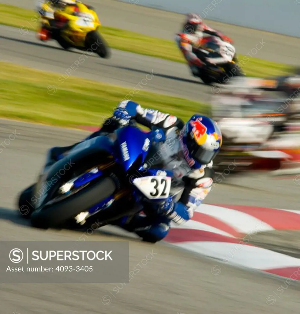 AMA motorcycle sports racing bike during a race.  a Yamaha leans into the turn with riders behind him