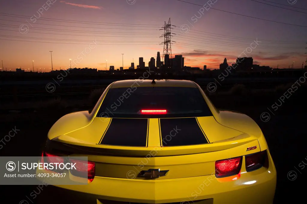 Static straight on rear view of a yellow tuner 2011 Chevrolet Camaro Forgiato at dusk in Los Angeles.