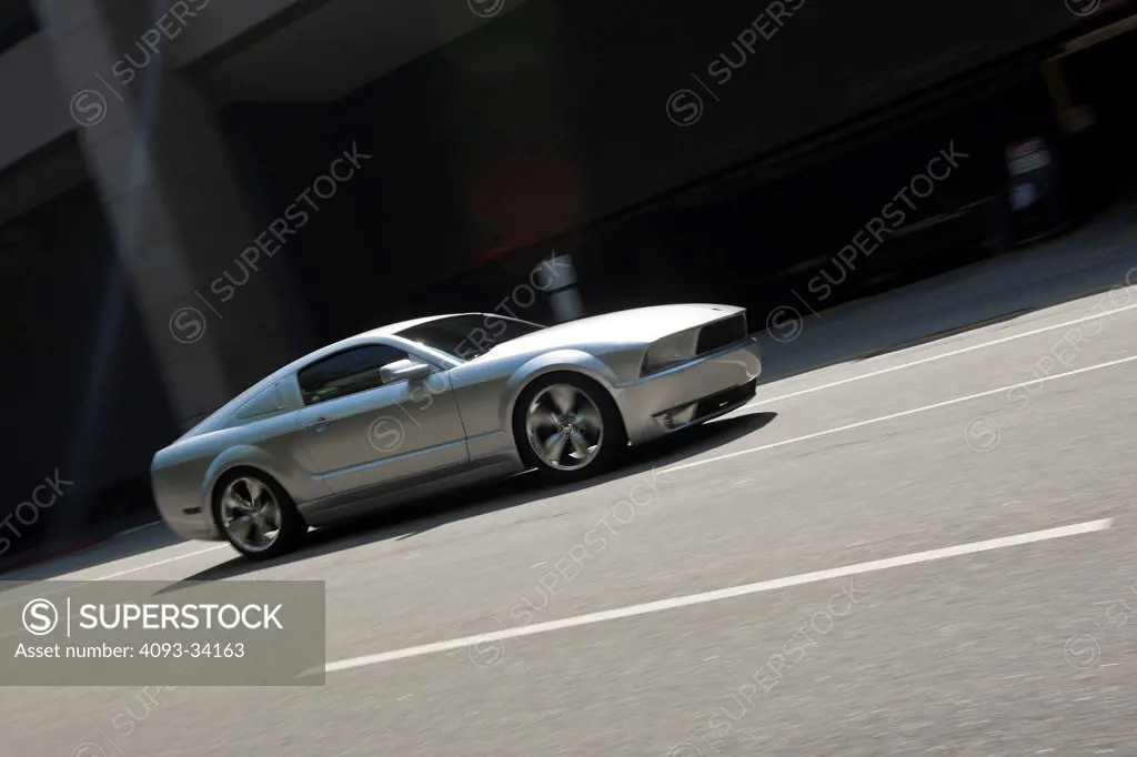 Front 3/4 action of a silver 2011 Ford Mustang GT Lacotta driving on an urban city street.