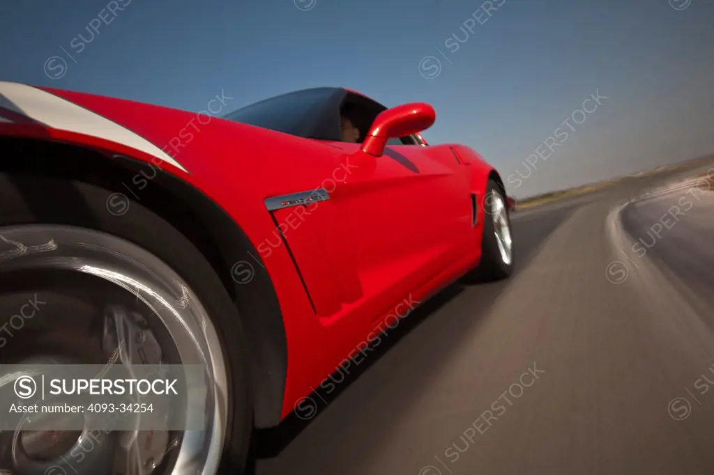 Exterior detail action of a red 2011 Chevrolet Corvette C6 Grand Sport showing the front left wheel, tire, brake caliper.