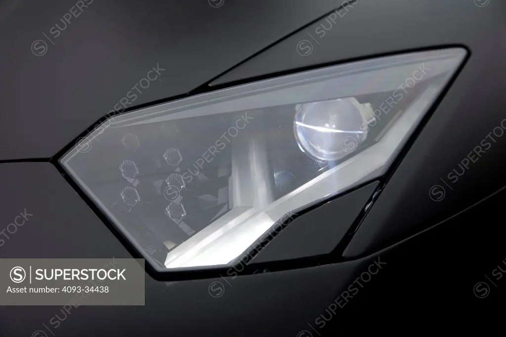 Exterior detail view of a satin black 2012 Lamborghini Aventador showing the headlight headlamp.