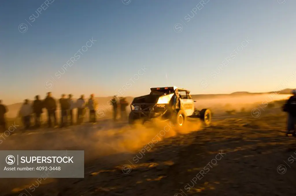Baja desert race trucks spinning and kicking up dirt and dust.