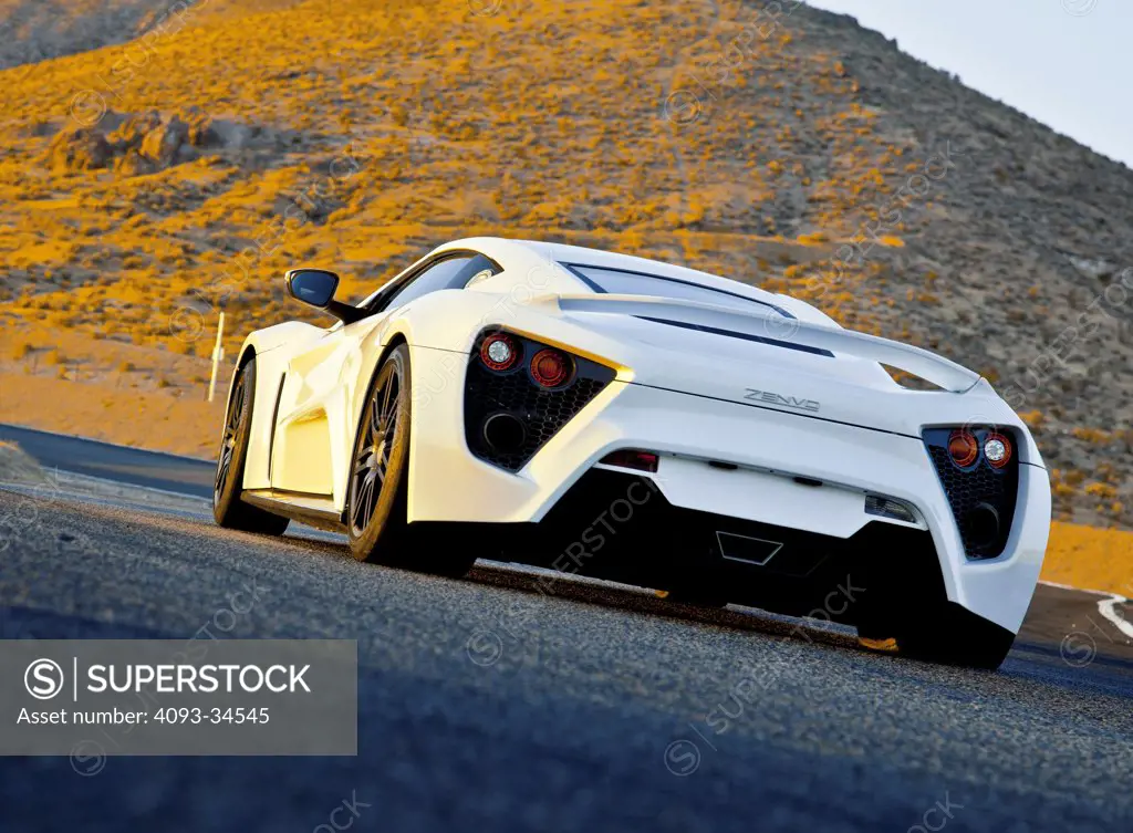 Rear 3/4 static view of a white 2012 Zenvo ST-1 at Willow Springs, California racetrack.