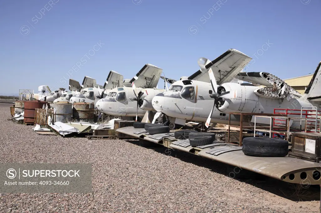 Abandoned US Navy 1954 Grumman S-2 Tracker aircraft lined up at a rural aircraft salvage yard.